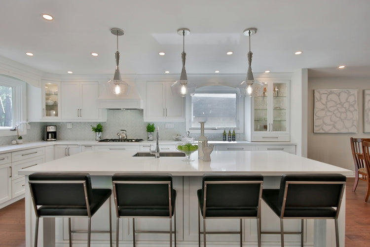 a kitchen with a center island with four chairs