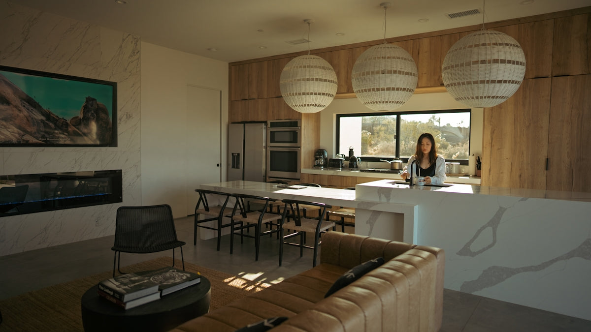 Woman standing in a modern kitchen and living area.