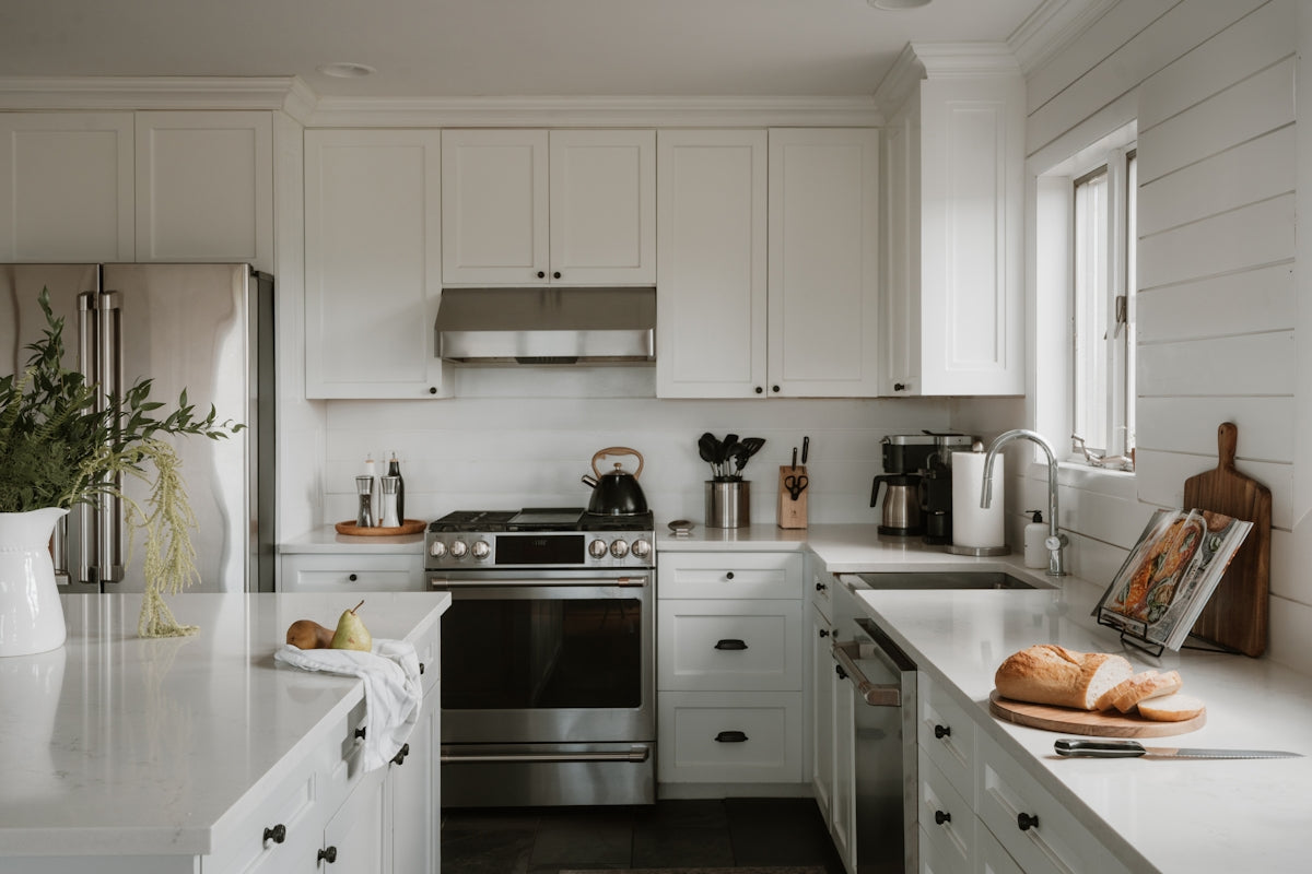 Bright, modern kitchen with white cabinets and stainless steel appliances.