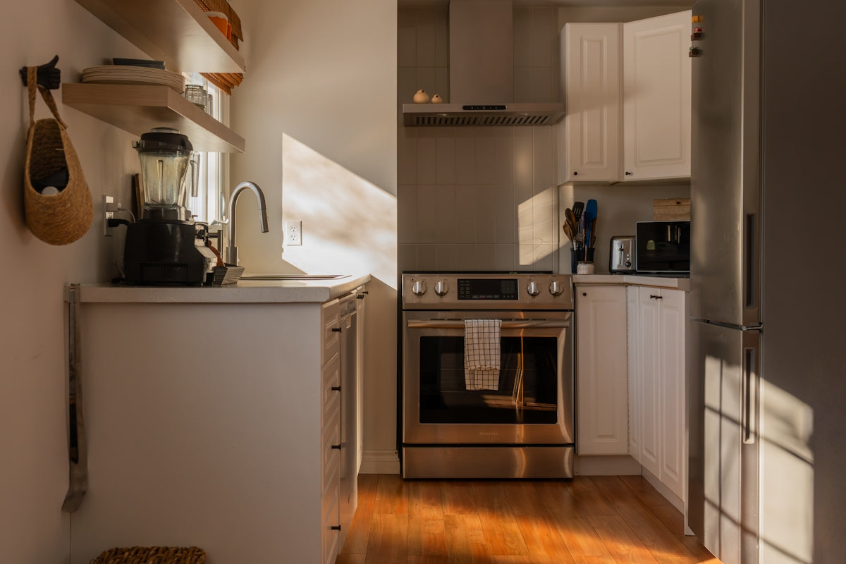 A modern kitchen with stainless steel appliances and wooden floors.