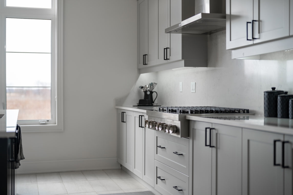 Modern white kitchen with stainless steel appliances.